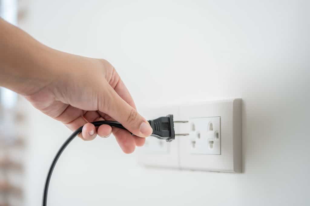 Human hand put in or out electric plug in the socket to connect the devices