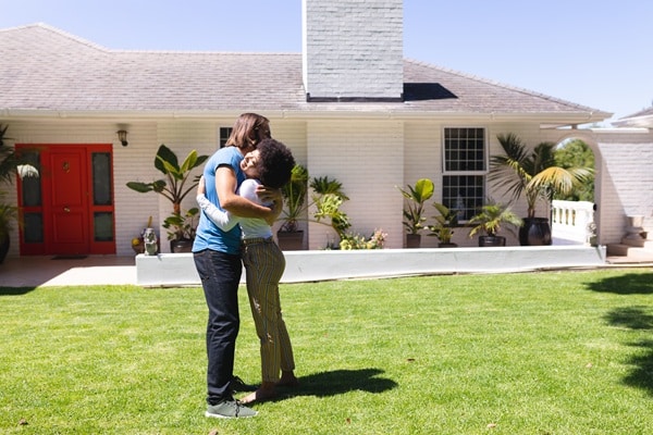 Happy couple in front of home